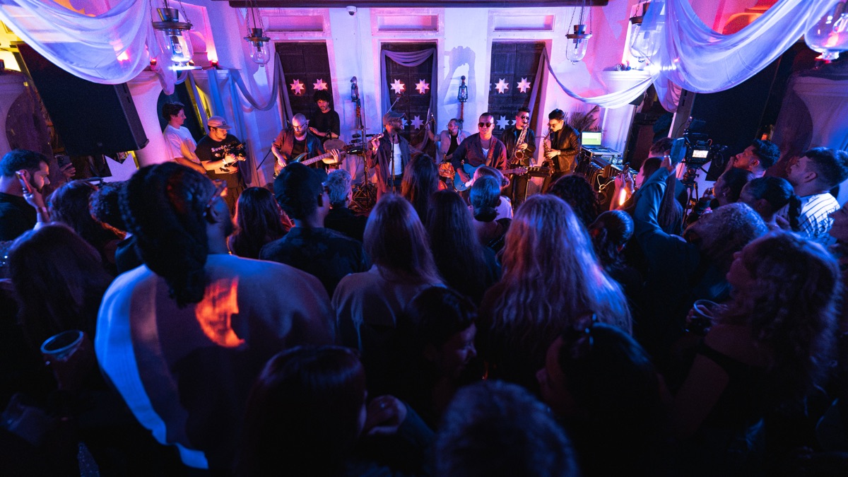 The band mid-set, seen from the back of a packed room