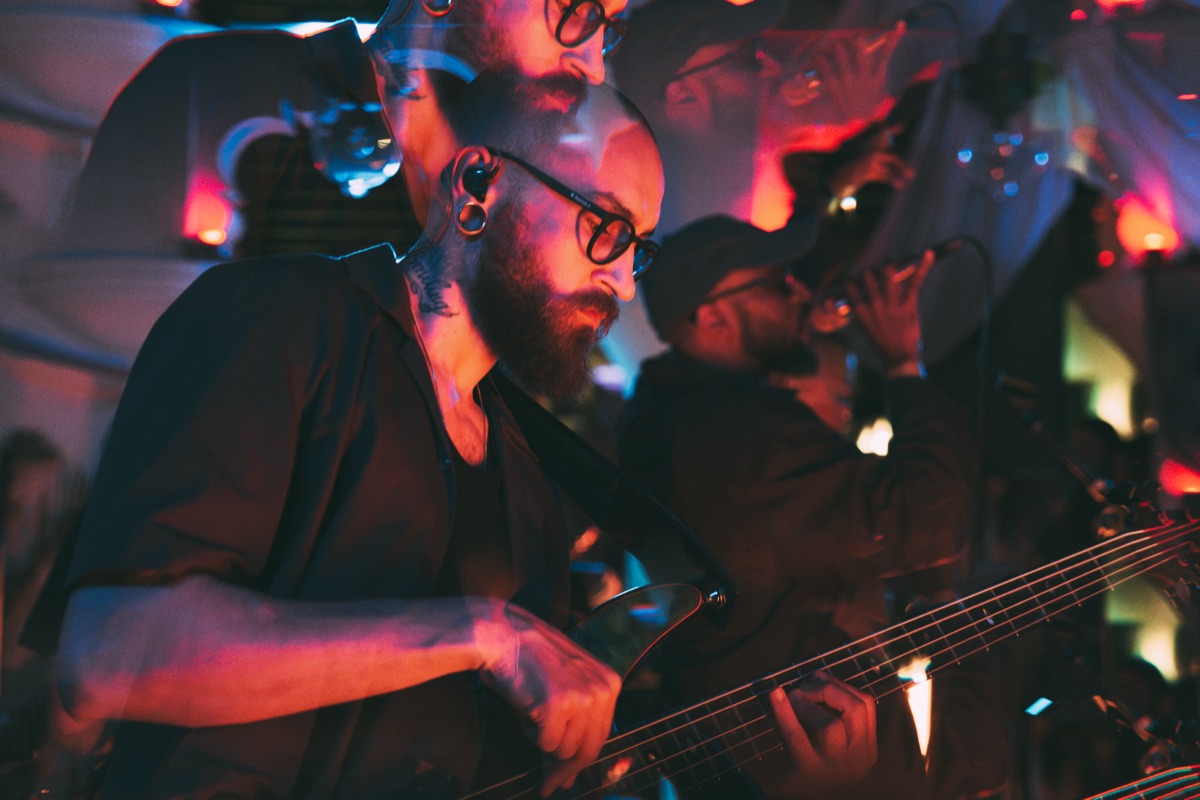 The bass player in close-up, lit red