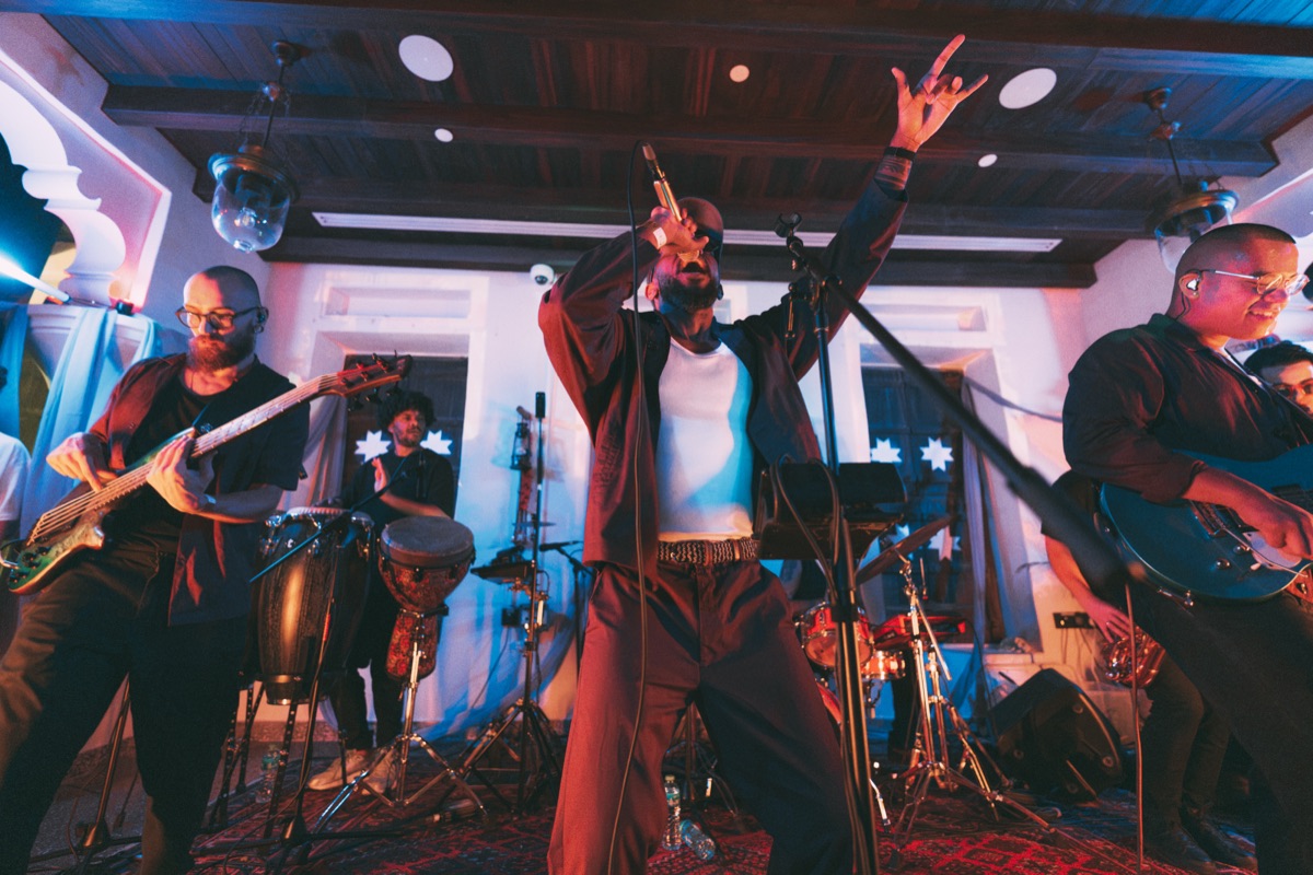 The singer mid-song with the band either side