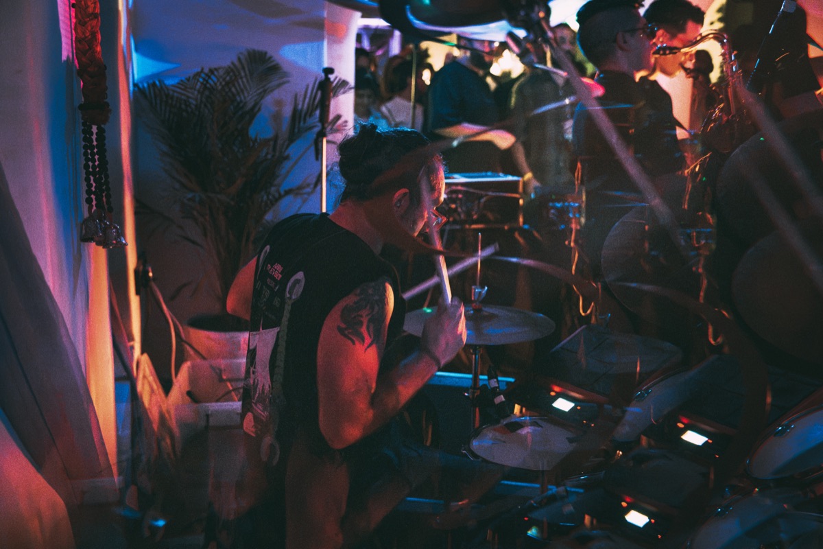 The drummer mid-song, cymbals catching the light