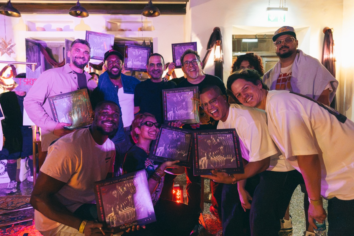 The band and crew with their framed prints, all laughing